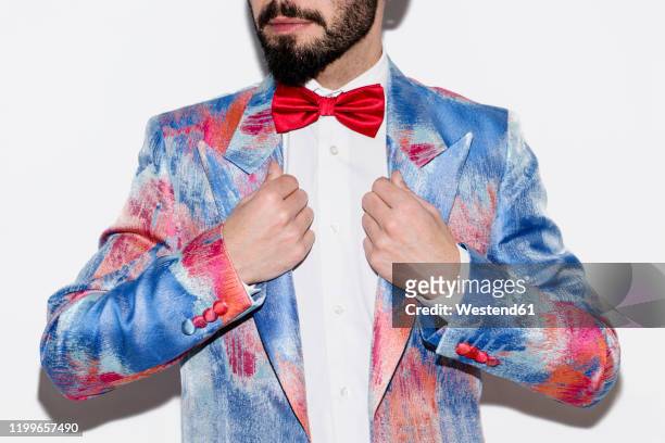 stylish man wearing a colorful suit and a red bow tie - red suit stockfoto's en -beelden