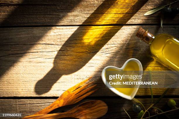 olive oil bottles and heart shape bowl as heart healthy food - wellness olive tree stock pictures, royalty-free photos & images