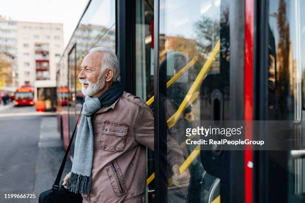 uomo d'affari senior che utilizza i mezzi pubblici - autobus - tram foto e immagini stock