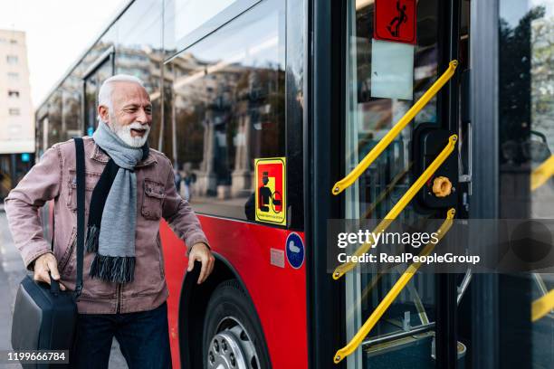 homme d'affaires aîné utilisant le transport public - autobus - entering photos et images de collection