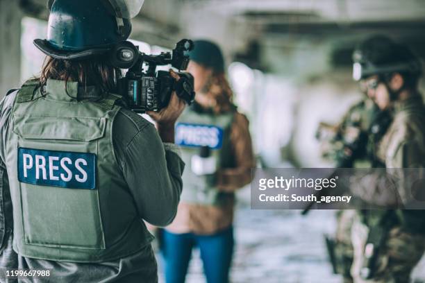 periodistas informando desde la zona de guerra - reporter fotografías e imágenes de stock