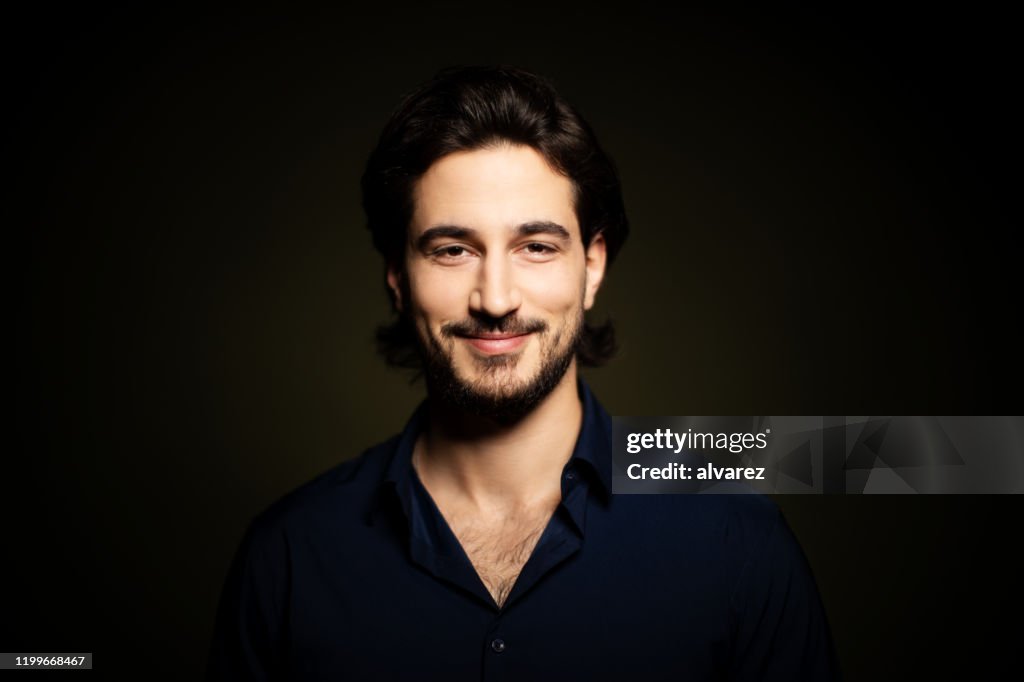 Portrait of attractive young man on dark background