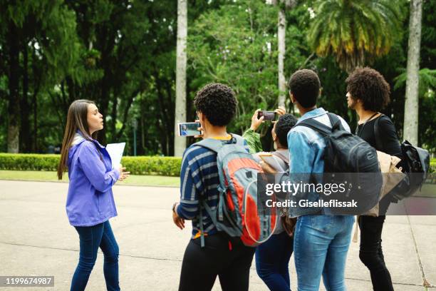 amigo do grupo de turistas que visitam lugares famosos e que tomam fotos com um guia de excursão - guide - fotografias e filmes do acervo