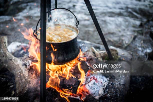 https://media.gettyimages.com/id/1199676818/photo/preparing-food-in-cooking-pot-on-campfire.jpg?s=612x612&w=gi&k=20&c=1NK-neDRQ5g-jub7N1DF8fX1LA8h9GIKZ-vcb06YXzA=