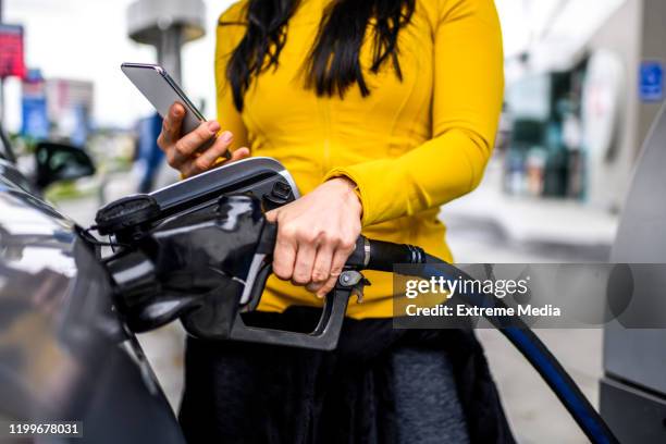 riempire un'auto di benzina in una stazione - fare il pieno di benzina foto e immagini stock