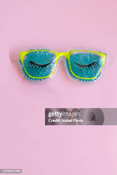 blue eye mask on pink background - plastic surgery stockfoto's en -beelden