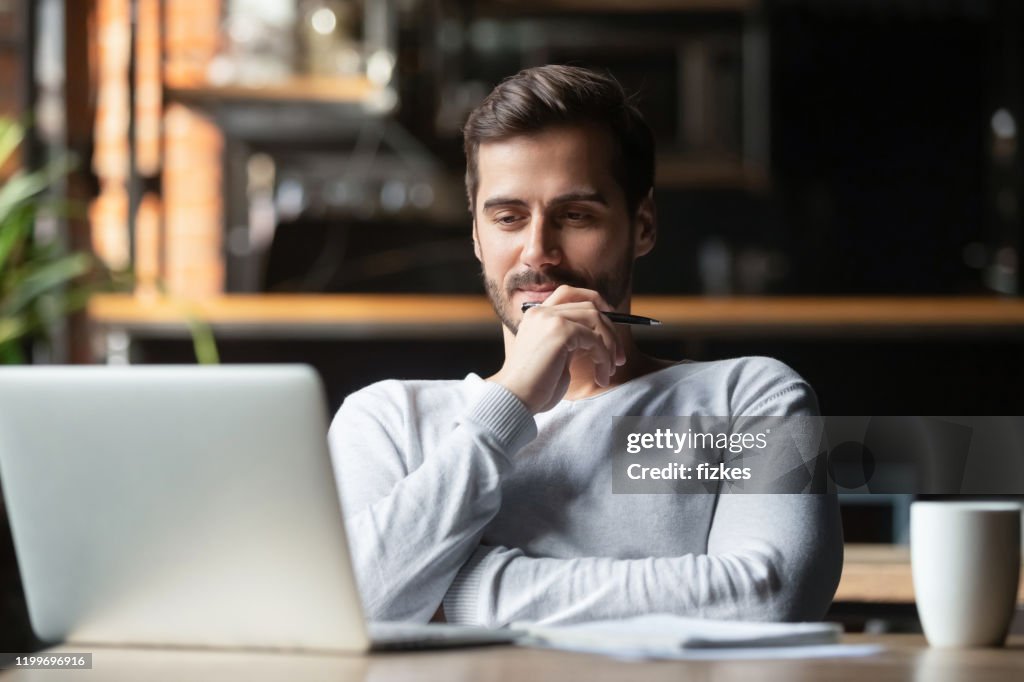 Thoughtful businessman think of online project looking at laptop