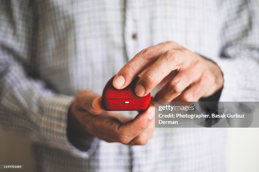 A man holding a red ring box