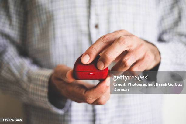 a man holding a red ring box - engagement imagens e fotografias de stock