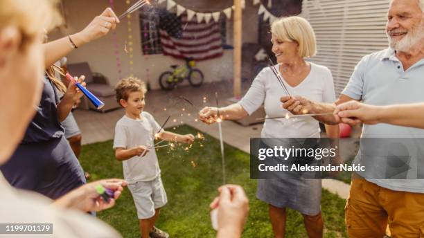 familia multigeneracional celebrando el 4 de julio - cuatro de julio fotografías e imágenes de stock