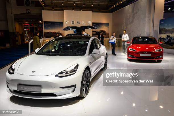 Tesla Model 3 compact sedan car in white with a Tesla Model S dual motor all electric sedan on display at Brussels Expo on January 9, 2020 in...