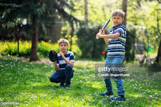 little boys playing baseball in the back yard - backyard baseball stock pictures, royalty-free photos & images