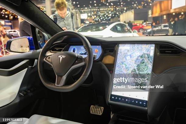 Interior on a Tesla Model X full electric luxury crossover SUV car with a large touch screen and carbon look dashboard on display at Brussels Expo on...