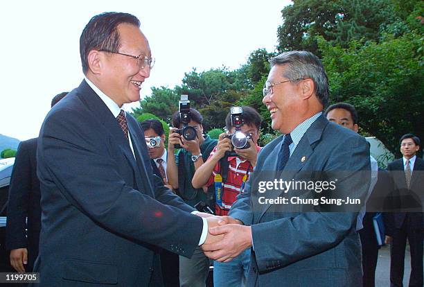 Chinese Foreign Minister Tang Jiaxuan is greeted by his South Korean counterpart Choi Sung-hong before a meeting at Choi's residence August 2, 2002...