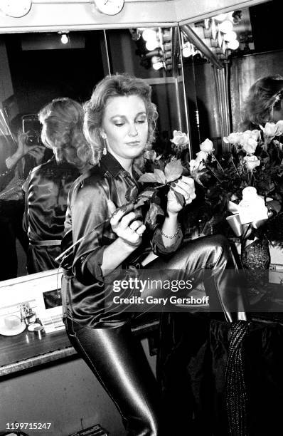 Portrait of American Country musician Tanya Tucker, a bouquet roses in her hands, as she poses backstage prior to a performance at the Bottom Line,...