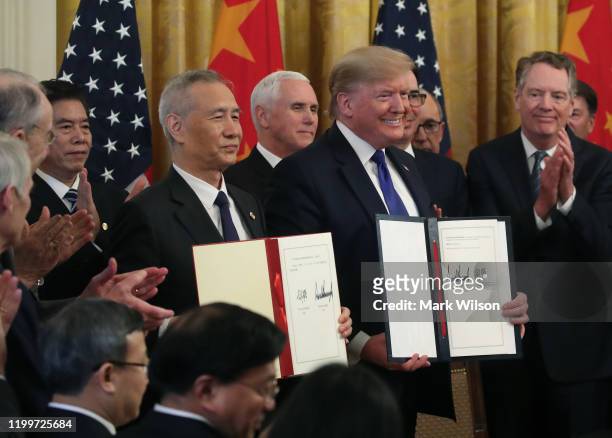 President Donald Trump and Chinese Vice Premier Liu He, hold up signed agreements of phase 1 of a trade deal between the U.S. And China, in the East...