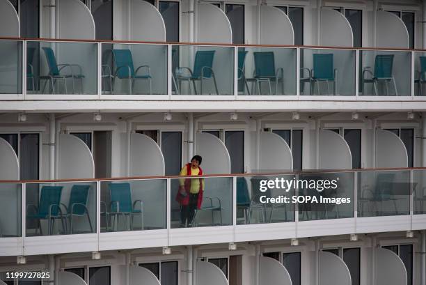 Passenger yawns on a balcony aboard at the Dream World cruiser as passengers leave the ship. 3,600 passengers and crew members quarantined on World...