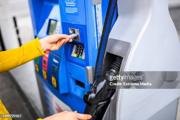 paying for fuel using a credit card at a gas station - fuel nozzle stock pictures, royalty-free photos & images