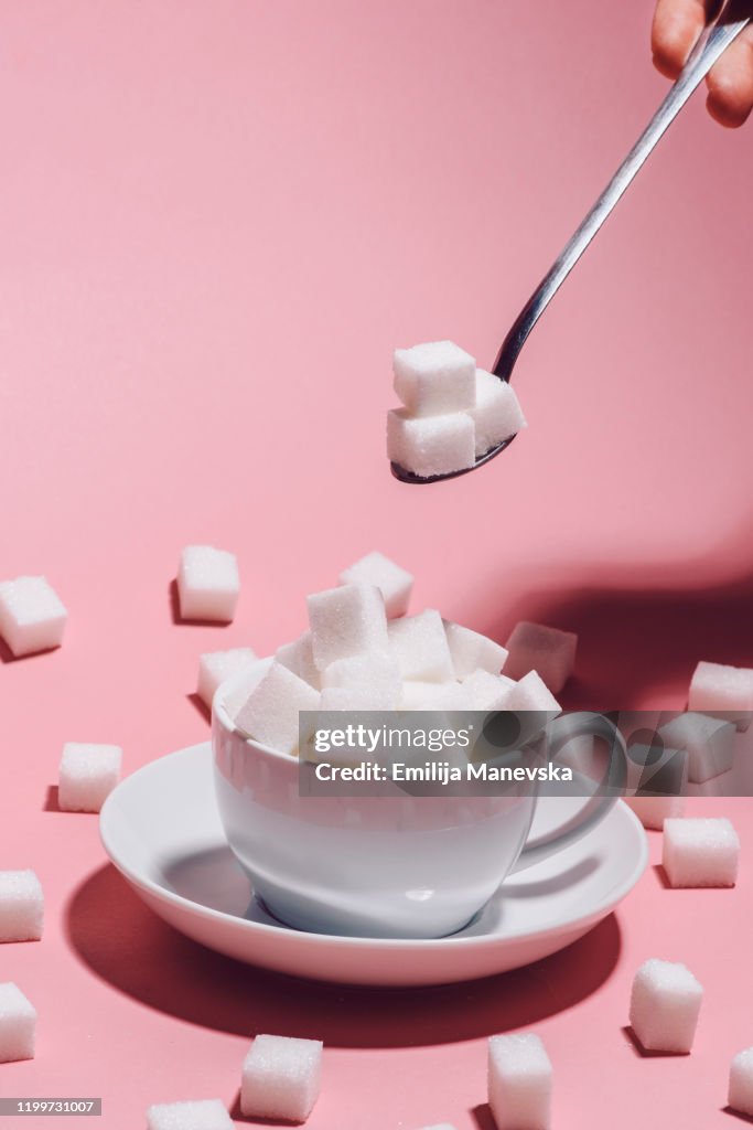 White cup full of sugar cubes