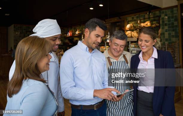 business manager taking a look at the menu with his staff at a cafe - chef team stock pictures, royalty-free photos & images