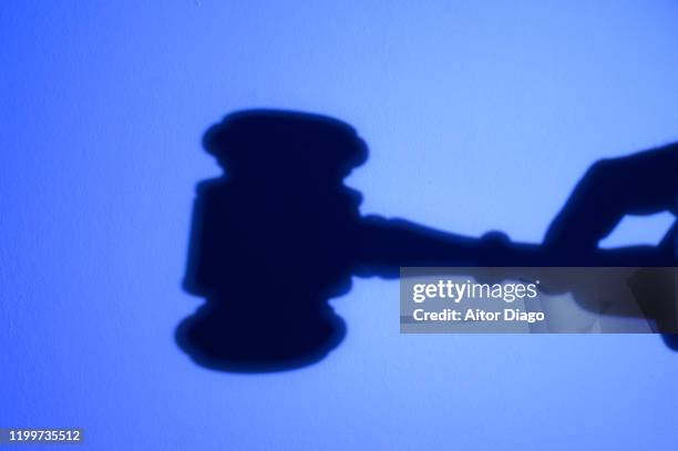 silhouette of hand with a judge's gavel. suspense of payments. - criminal justice concept stock pictures, royalty-free photos & images