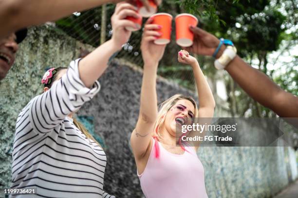 glückliche freunde gruppe toasting auf einer karnevalsparty in brasilien - bier fasching stock-fotos und bilder