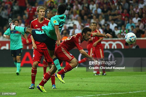 Alcantara Thiago of Barcelona scores the first goal against Diego Contento of Bayernduring the Audi Cup final match between FC Bayern Muenchen and FC...