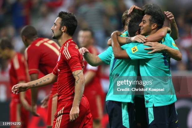 Alcantara Thiago of Barcelona celebrates the first goal with his team mates and Diego Contento of Bayern looks dejected during the Audi Cup final...