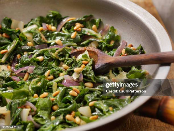 garlic and butter sautéed swiss chard with toasted pine nuts - pinion stock pictures, royalty-free photos & images