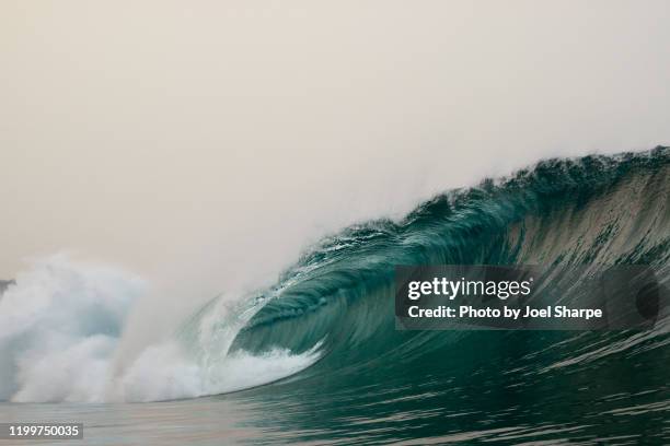 a barreling wave in the smoke of the australian bushfires in 2020 - big wave stock pictures, royalty-free photos & images