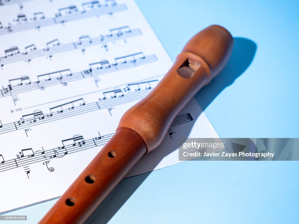 Recorder And A Sheet Music On Blue Background