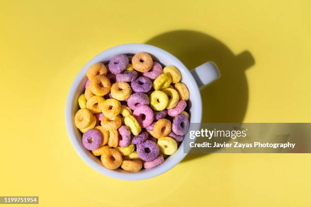 colorful corn rings in cup on yellow background - bowl of cereal stock pictures, royalty-free photos & images