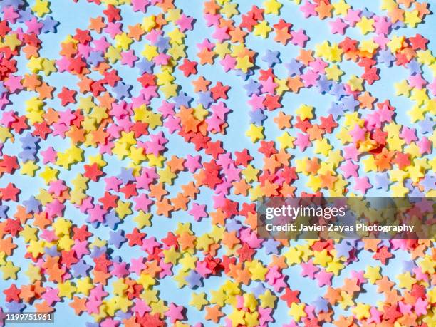 sugar stars on blue background - sprinkles stock pictures, royalty-free photos & images