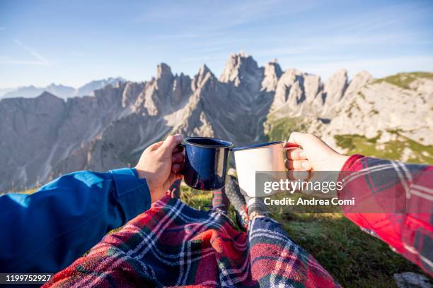 personal perspective of people holding a coffee cup enjoying the view at cadini di misurina - coffee cup top view stockfoto's en -beelden