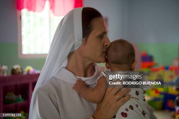 Director of "Hogar Valle Feliz" reception center Carmela Ewa Pilarska, plays with the son of a teenage mother at the reception center, in Santo...