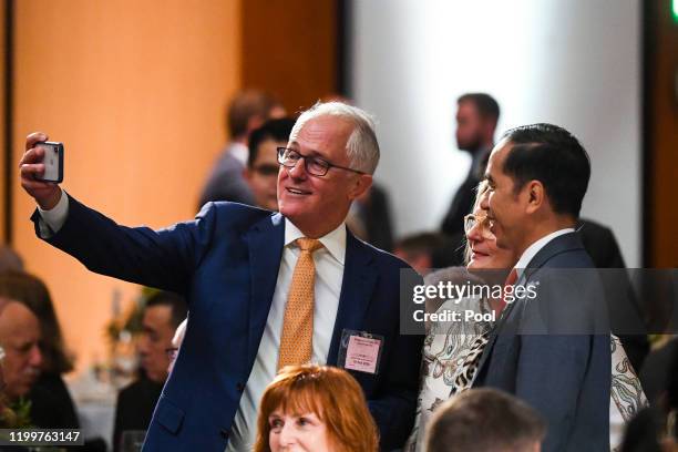 Former Australian Prime Minister Malcolm Turnbull and his wife Lucy take a selfie photograph with Indonesian President Joko Widodo as they attend an...