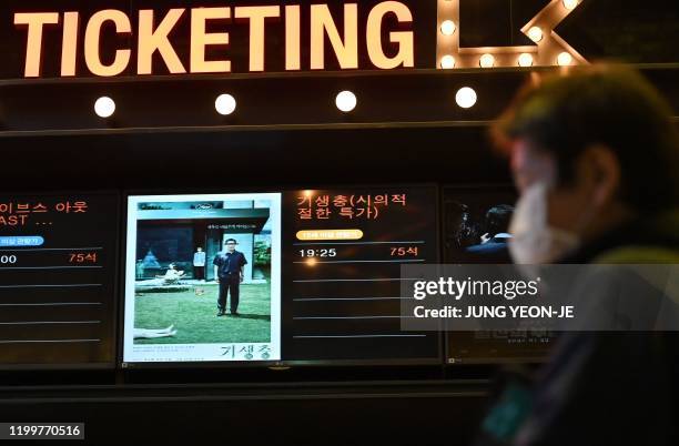 Man walks past a screen showing a poster of Bong Joon-ho's film 'Parasite' at a cinema in Seoul on February 10, 2020. - South Korea on February 10...