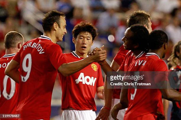 Anderson and Ji-Sung Park of the Manchester United congratulate teammate Dimitar Berbatov on his goal against the MLS All-Stars during the second...