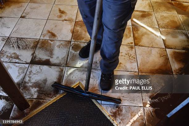 Man cleans up inside the Appleby and District Community First Responder Group meeting room in Appleby, northwest England, on February 10, 2020 after...