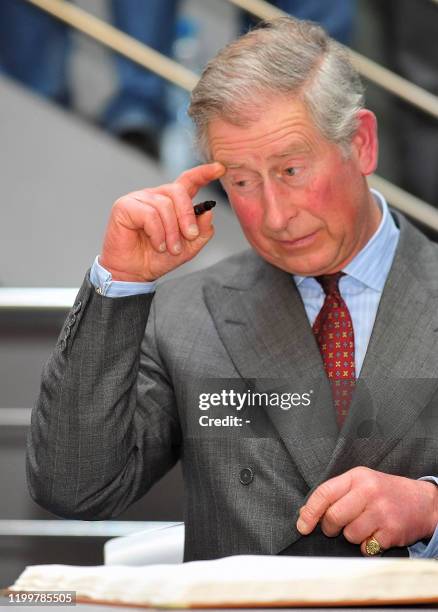 Britain's Prince Charles prepares to signs an autograph in the university visitors book during his visit to Masaryk University in Brno, on March 22,...