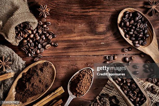 achtergrond van koffiebonen en gemalen koffie op een rustieke tafel - geroosterde koffieboon stockfoto's en -beelden