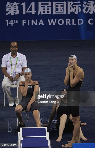 Veronika Popova, Elena Sokolova and Viktoriya Andreeva of Russia look on as teammateKira Volodina swims the anchor leg in heat three of the Women's 4...