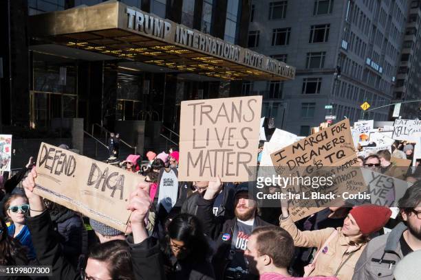Marcher holds a sign that say, "Trans Lives Matter" walking in front of Trump International Tower during the second annual Women's March in the...