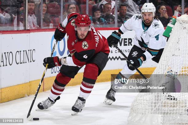 Niklas Hjalmarsson of the Arizona Coyotes skates with the puck ahead of Brenden Dillon of the San Jose Sharks during the first period of the NHL game...