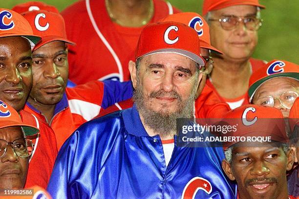 Cuban President and honorary coach Fidel Castro , surrounded by his team, smiles late 18 November 1999 after a friendly game between ball veterans...
