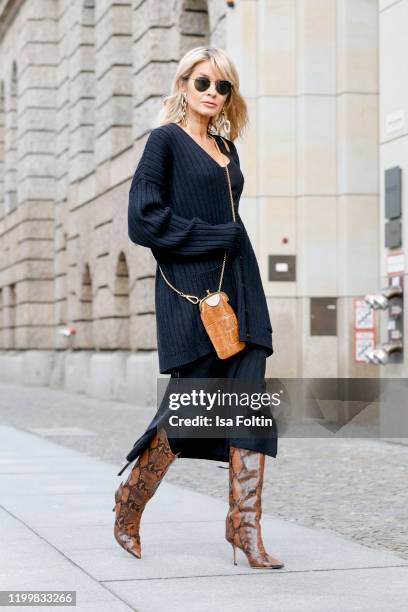 Influencer Gitta Banko is wearing an oversized black wool cardigan and a black wool skirt by Boscana x Gitta Banko, a black ribbed tanktop by Zara,...