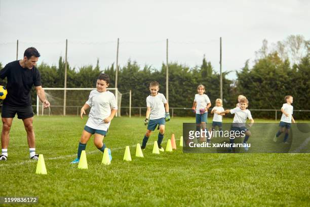 preteen spanish footballers doing agility drills with coach - sports training drill stock pictures, royalty-free photos & images
