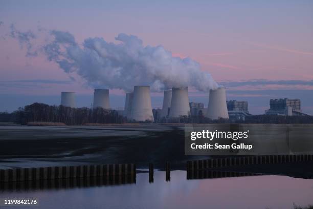 Steam rises from cooling towers at the Jaenschswalde lignite coal-fired power plant at twilight on January 15, 2020 in Peitz, Germany. The European...