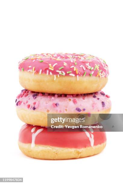 stack of donuts with colourful sprinkles isolated on white background - pile of candy stock pictures, royalty-free photos & images