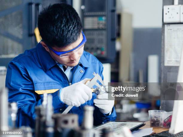 asian engineer using a calliper for quality control - vernier calliper stock pictures, royalty-free photos & images
